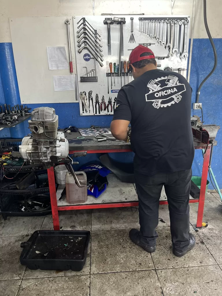 Mecânico RM Moto Peças instalando bateria de moto